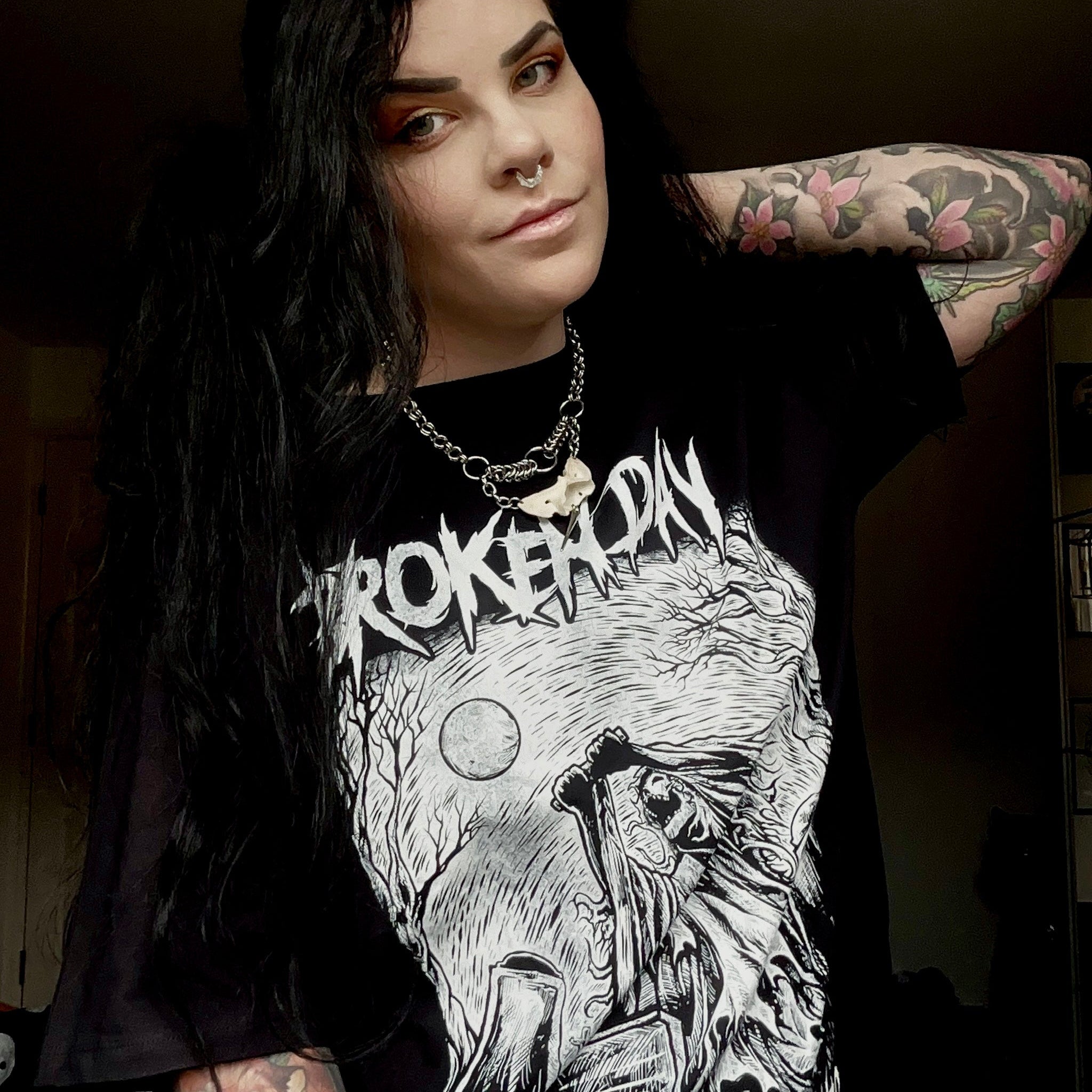 A person wearing a black t-shirt with 'Architects' text and a monochrome graphic print.