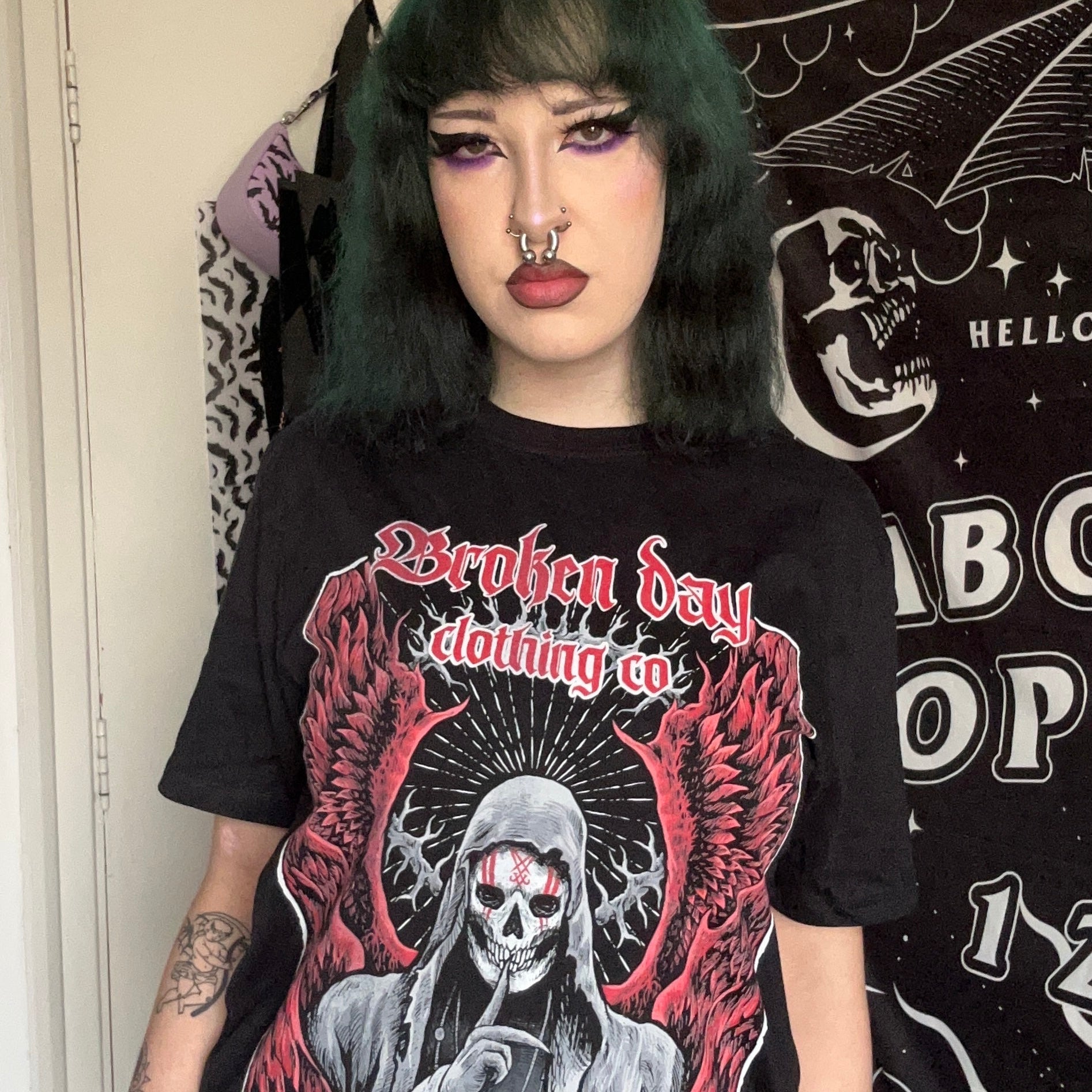A person wearing a black t-shirt with a graphic design inspired by Sleep Token's The Summoning song.
