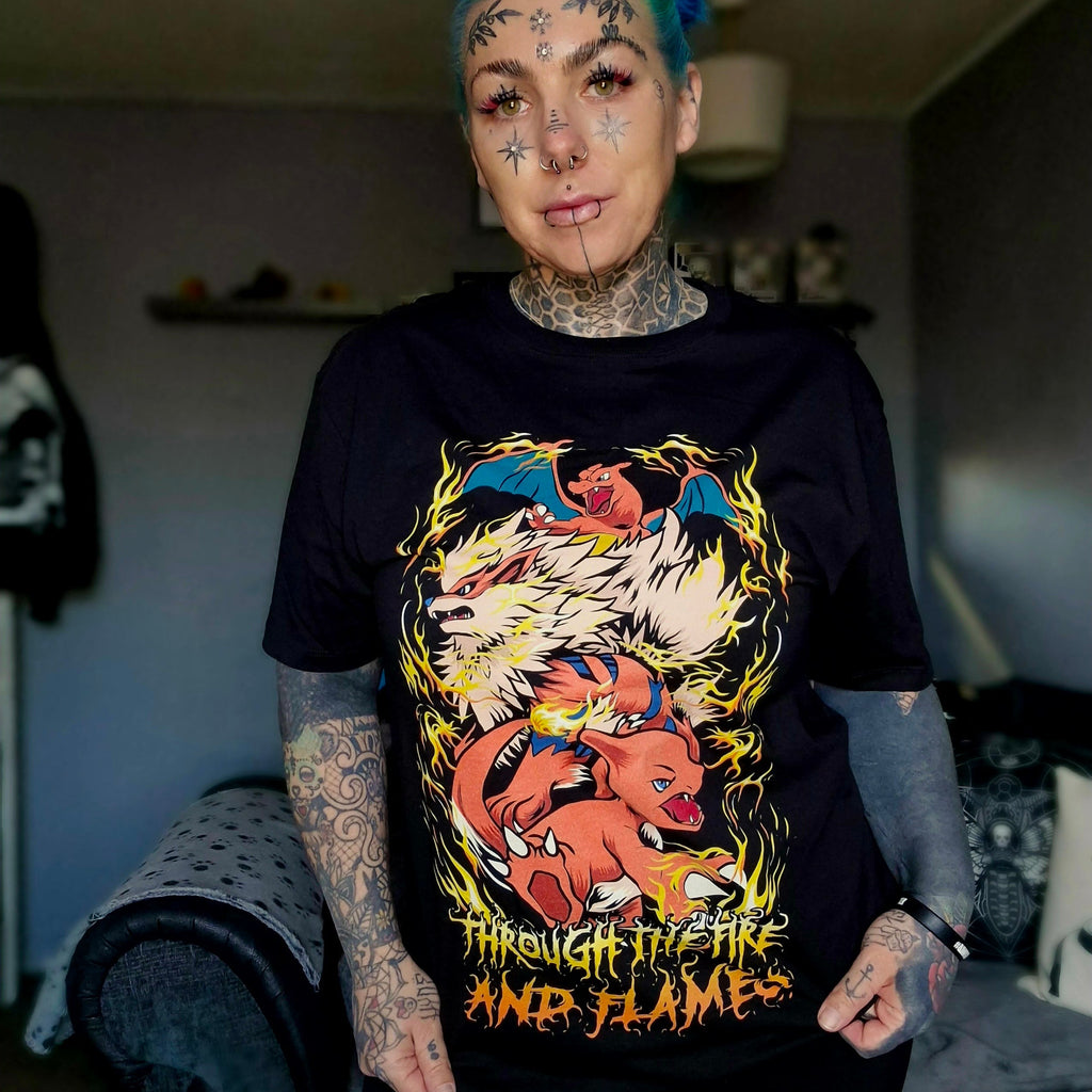 A person with blue hair and tattoos wearing a black t-shirt with a graphic design of a dragon inspired by Dragonforce and Pokémon.