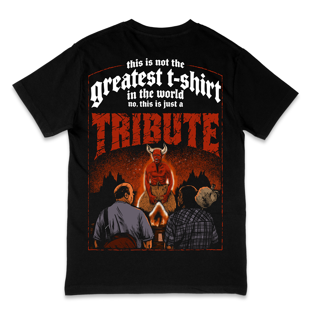 A black short-sleeve t-shirt with a large red and white graphic print on the front, featuring the text 'this is not the greatest t-shirt in the world no. this is just a TRIBUTE' and an illustration of a horned figure above two men sitting by a campfire.