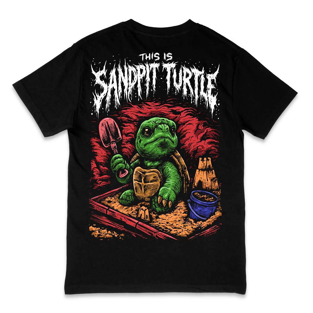 A black short-sleeve graphic t-shirt featuring a cartoon green turtle in a sandbox holding a shovel, with the text 'THIS IS SANDPIT TURTLE' in a distressed white font above it.