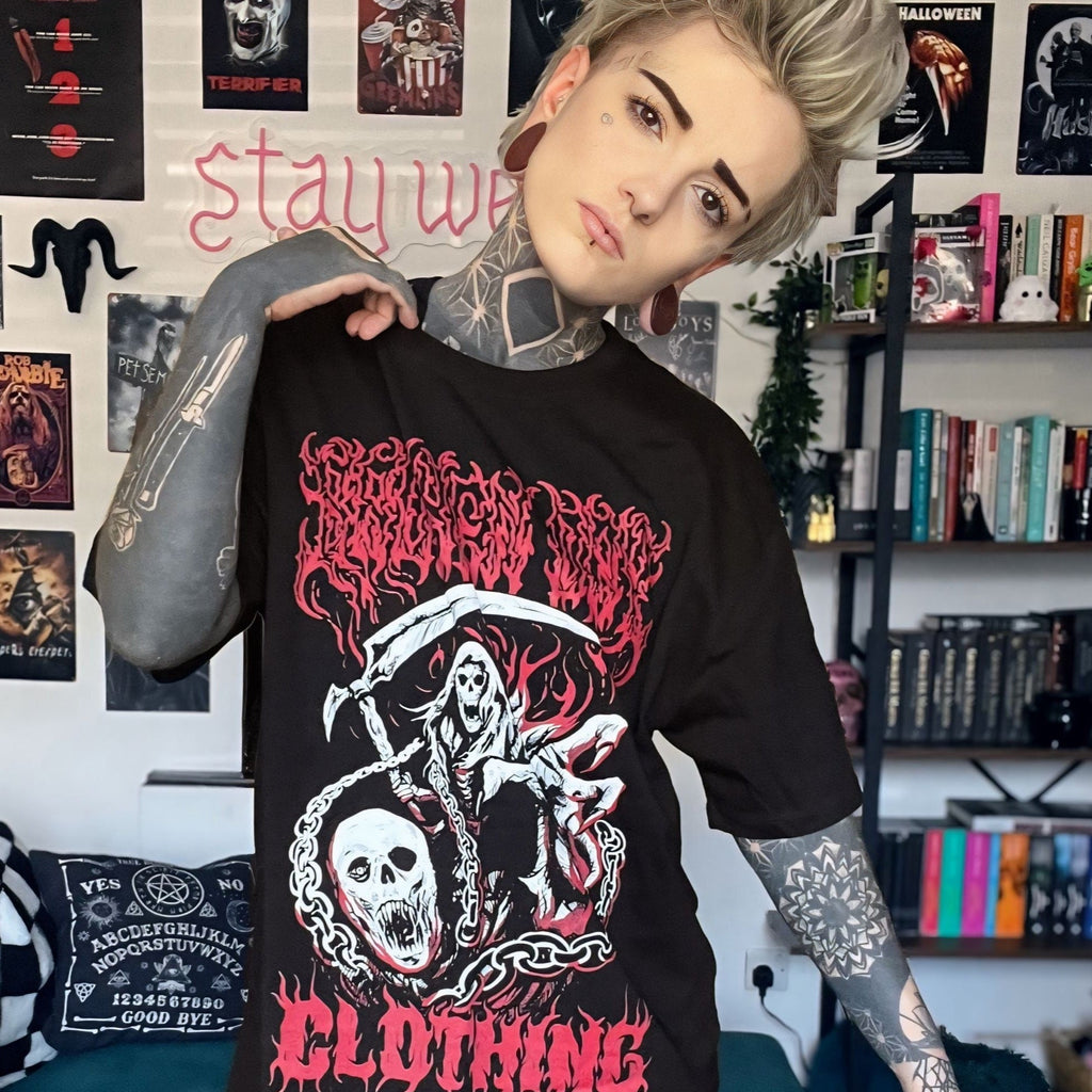 Person wearing a black graphic t-shirt in a room with posters and books on the wall.