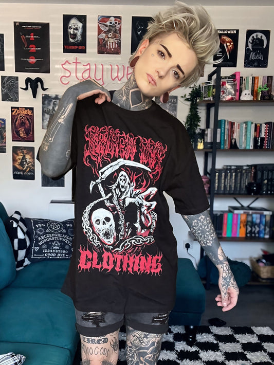 Person wearing a black graphic t-shirt in a room with posters and books on the wall.